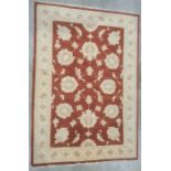 Modern Eastern-style red ground rug with foliate decoration to the central field, cream ground