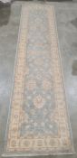 Modern Oriental-style duck egg blue ground runner with cream foliate decoration and cream ground