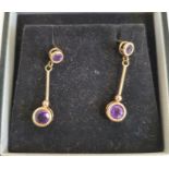 Pair of gold-coloured drop earrings, each set with two circular mixed cut amethysts, unmarked,