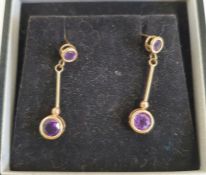 Pair of gold-coloured drop earrings, each set with two circular mixed cut amethysts, unmarked,