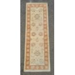 Cream ground runner with foliate decoration, peach ground border, 182cm x 62cm