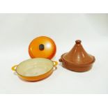 Le Creuset two-handled cast iron shallow dish and cover in orange enamel, 37cm wide over the handles