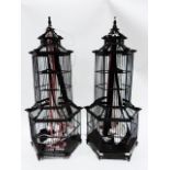 Two black painted wooden decorative pagodas/birdcages of hexagonal tier design hung with ribbons (