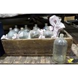 Ten vintage bottles held within a wooden carrier, probably decorative purposes only, with deliberate