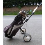 Golf clubs within a golf caddy on wheels and the golf clubs seem to be mainly by Tanaka