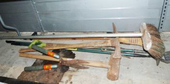 Assorted garden tools to include a sledge hammer, a brush, besom broom, shears, a pickaxe, a fork,