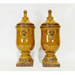 Pair of modern treacle glazed ceramic urn-shaped lidded vases with applied lion decoration (2)