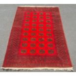 Modern Afghan rug, the central field with elephant foot guls on a red ground with multiple