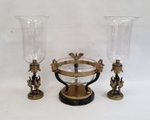 Modern metal garniture comprising a pair of lamps supported by sphinxes with glass storm shades