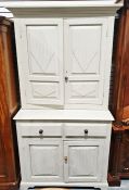 Painted cabinet with moulded cornice above two cupboard doors, the base with two drawers and two