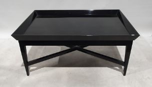 Rectangular black ground modern coffee table on tapering supports, 121cm x 55cm