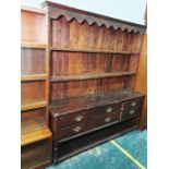 Early 20th century stained pine dresser, the moulded cornice above open shelves, the base with six