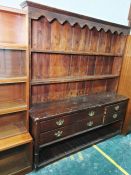 Early 20th century stained pine dresser, the moulded cornice above open shelves, the base with six