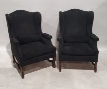 Pair of modern wing back office reception chairs upholstered in black, on carved feet and stretchers