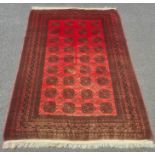 Modern Afghan rug, the central field with elephant foot guls on a red ground with multiple