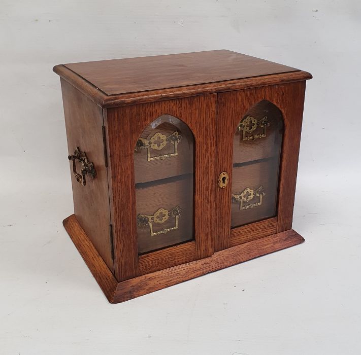 Edwardian oak smoker's cabinet, the two glazed doors with bevelled glass revealing two drawers, 26cm