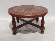 Circular coffee table with brown leather top with aztec design, on turned and block supports,