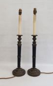 Pair of table lamps with fluted black composite stems and bronze-effect mounts, decorated with