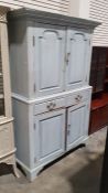 20th century painted cabinet, the moulded cornice above two panelled doors enclosing shelves, the