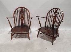 Pair of dark elm Ercol low armchairs with carved and pierced backsplats, on turned supports and