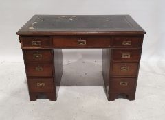 Campaign-style pedestal desk of nine drawers, leatherette top, moulded edge, on bracket feet, 101.