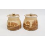 Pair of Rupert Andrews "Mocha" ware lidded preserve jars decorated with country landscapes,