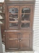 20th century oak corner display unit with two glazed doors enclosing shelves above two cupboard