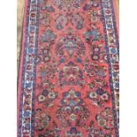 Persian wool runner 'Sarogh'-style, in red/pink ground with floral decoration in blues and greens,