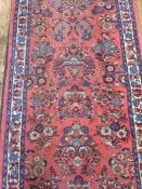 Persian wool runner 'Sarogh'-style, in red/pink ground with floral decoration in blues and greens,