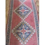 A Persian wool runner in red, blue and white with lozenge design, 370cm x 88cm