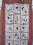 Embroidered and lace cloth backed onto linen, used as a door curtain, in shades of blues, pinks,