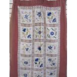 Embroidered and lace cloth backed onto linen, used as a door curtain, in shades of blues, pinks,