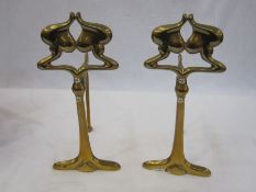 Pair of Art Nouveau brass firedogs with silver-coloured screws, 23.5cm high (2)