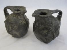 Two lead grinning mask ewers in the manner of the Martin brothers  16cm high (2)  Condition