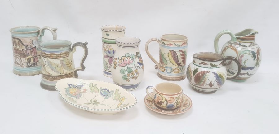 Two studio pottery mugs both with painted leaf decoration, another with painted interior scene,