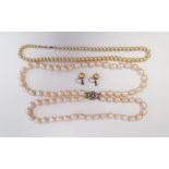 Double strand of large baroque type pearls on white metal paste set clasp and a graduating string of