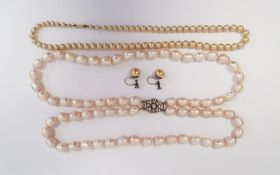 Double strand of large baroque type pearls on white metal paste set clasp and a graduating string of