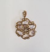 Gold brooch pendant set with seedpearls, with a central flowerhead within scrolling border, marked