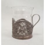 Silver-coloured metal filigree cup holder, flower decorated, with marks to base and a glass cup (not