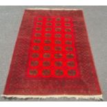 Modern Afghan rug, the central field with elephant's foot guls on a red ground with multiple