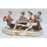Ciche porcelain figural group of boys seated at a table playing cards, the oval base with gilt