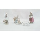 Lladro model of a seated boy with a dog, 19cm high, a Lladro figure of a girl with a basket of