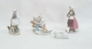 Lladro model of a seated boy with a dog, 19cm high, a Lladro figure of a girl with a basket of