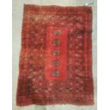 Red ground Eastern rug with five elephant's foot guls to the central field, stepped border, 110cm