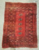 Red ground Eastern rug with five elephant's foot guls to the central field, stepped border, 110cm