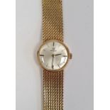 Lady's 18ct gold Omega wristwatch with circular dial, baton numerals, integral flexible mesh