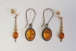Pair of 9ct gold drop earrings, each set with an oval amber cabochon and a pair of silver and