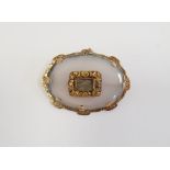 Victorian moonstone and gold-coloured metal mourning brooch, the oval stone bevelled and set with