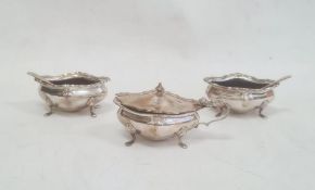 A 1920s silver three piece cruet set with two matching spoons, lozenge shaped, on splayed feet