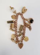 9ct gold curb link bracelet with 9ct gold padlock clasp, hung with assorted charms including a